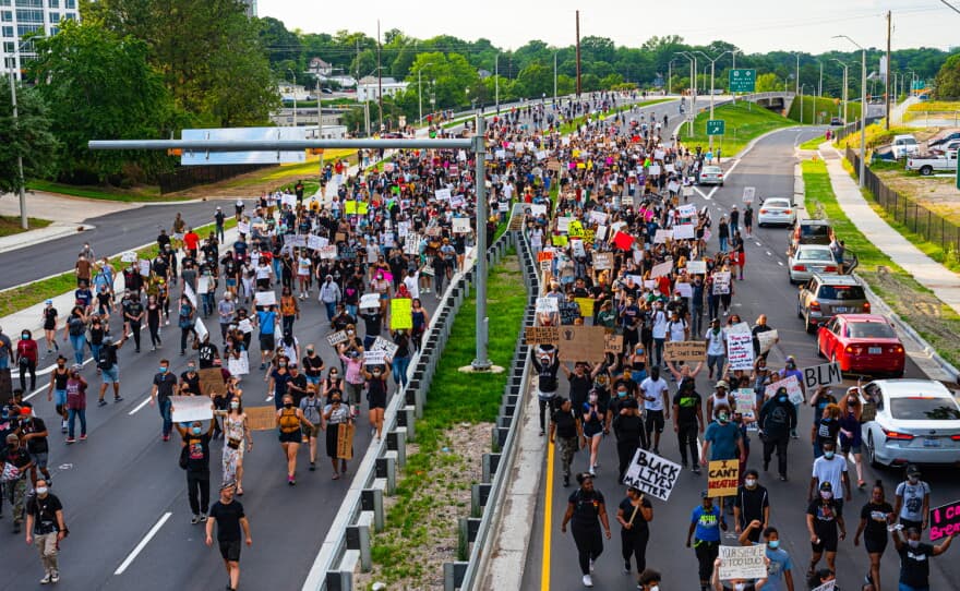 People marching in the street carrying signs